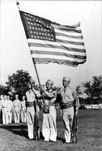 Japanese Americans in the U.S. military carrying the American flag during a ceremony