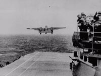 A plane taking off from a carrier in the ocean.