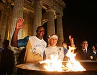 Torch bearers celebrate the Olympic flame's return to Athens.