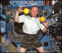 Astronaut Mike Fincke juggles fresh fruit in the Destiny laboratory at the ISS.