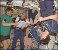 Astronauts at the ISS look over a procedures checklist.