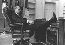 President Gerald Ford kicks back in his chair while on the telephone.