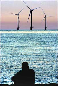 Wind turbines generating electricity near a European coastline.