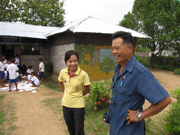 Winston Win, a Burmese refugee who returned from America to help his people in Thailand, laughs with the headmaster of Irrawaddy Flower Garden school.